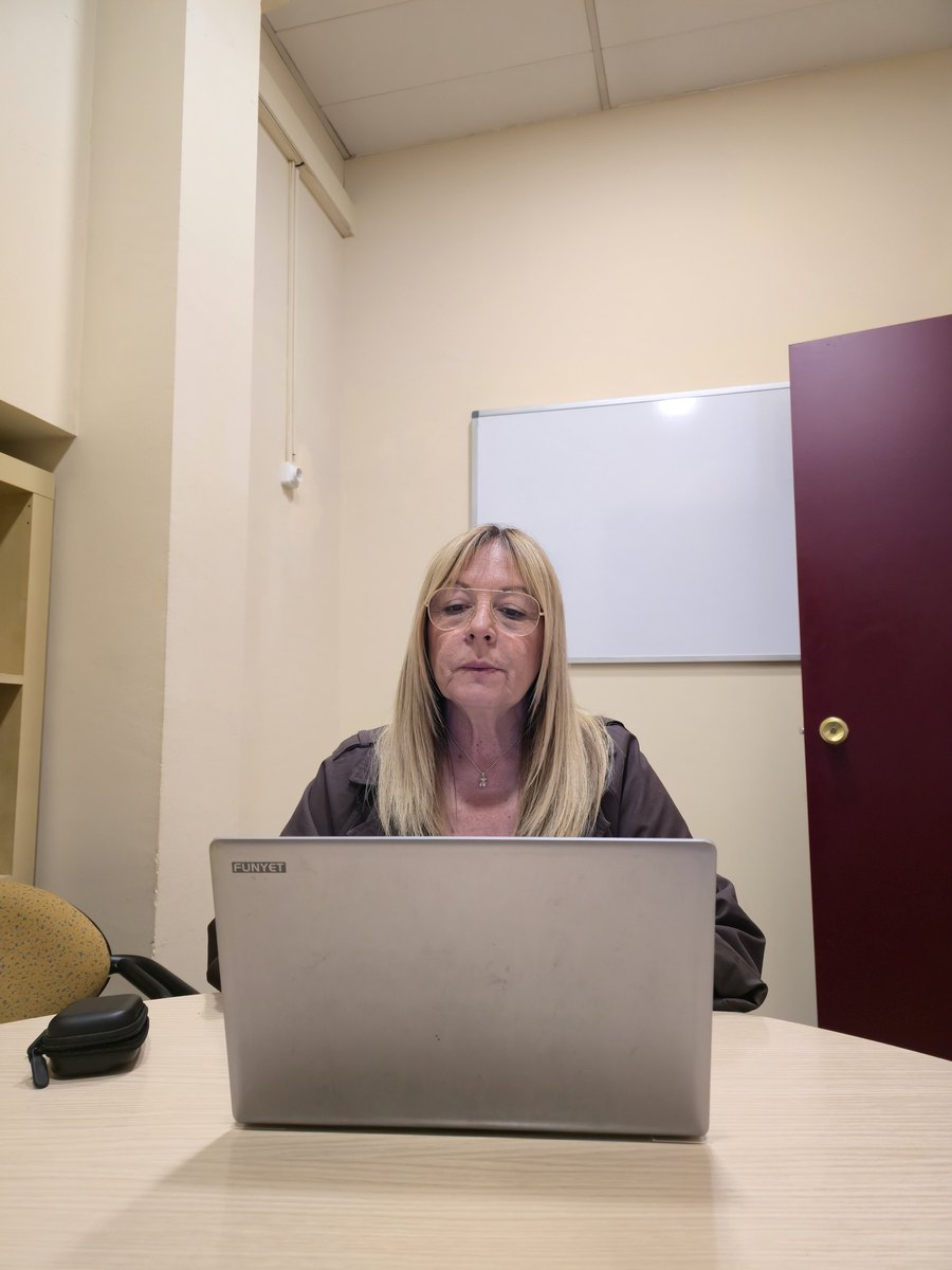 Núria, ajudant de coordinació d'Atention, treballant amb el portàtil a l'oficina de Sabadell