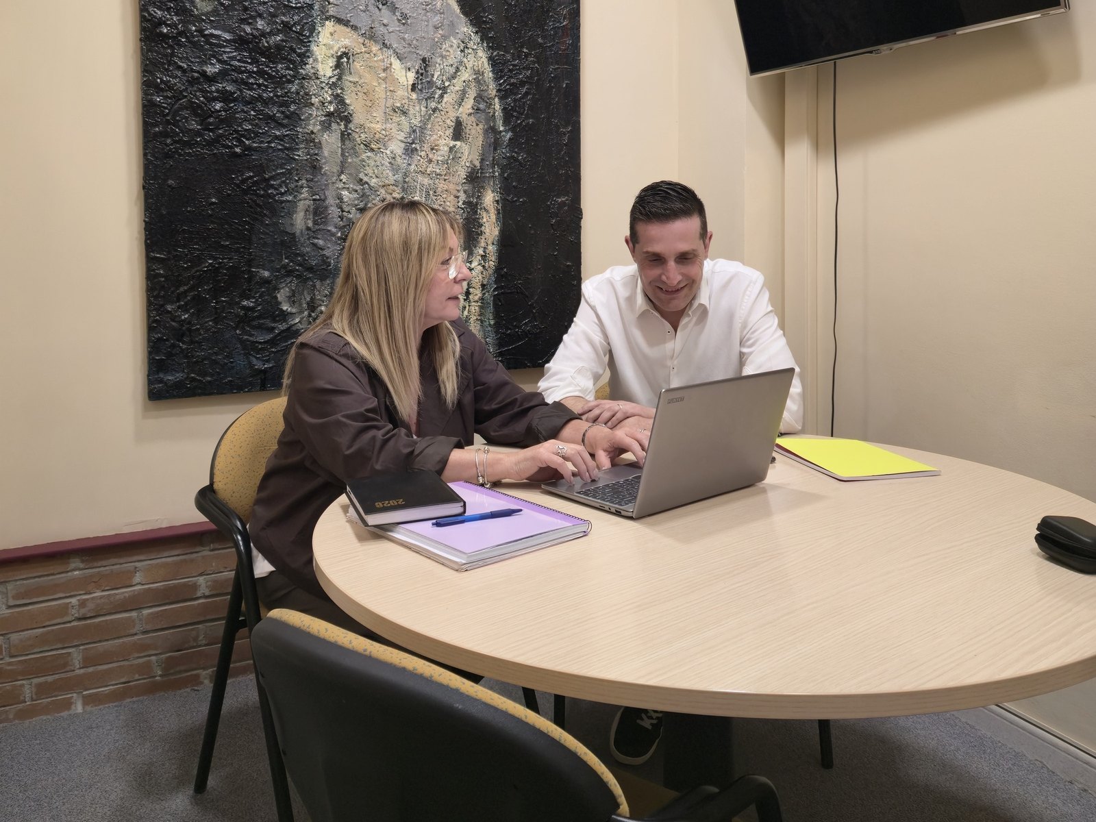 En Joan (responsable) i la Núria (ajudant de coordinació) d'Atention revisant un cas a l'oficina del Carrer Major, 13, Sabadell